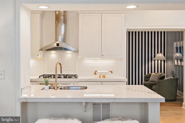 a kitchen with kitchen island stainless steel appliances a sink stove and refrigerator