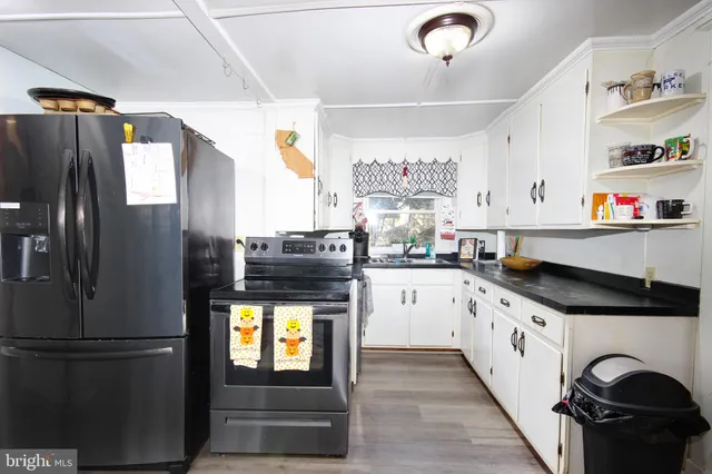 a kitchen with granite countertop a refrigerator and a stove top oven