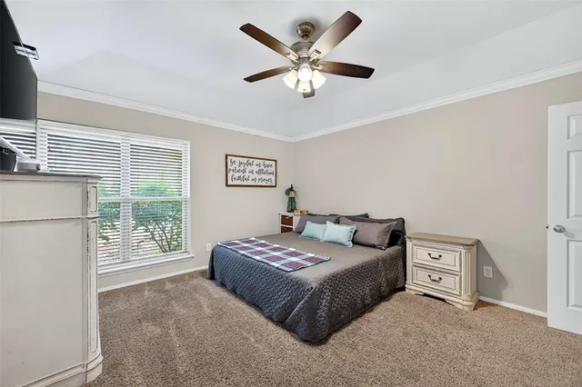 a bedroom with a bed a window and a chandelier
