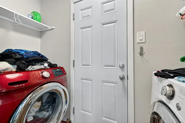 a bedroom with a bed and a washing machine in it