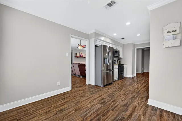 a view of kitchen with refrigerator and wooden floor
