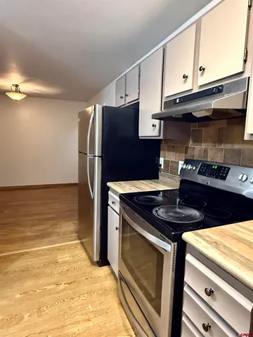 a kitchen with stainless steel appliances granite countertop a refrigerator and a stove top oven