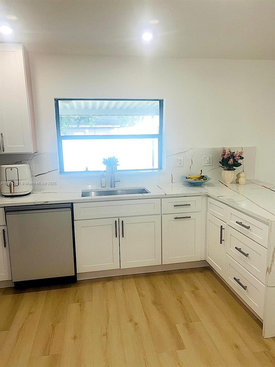 9703 Southwest 2nd Street Boca Raton, FL 33428 - Photo 11 of 17 a kitchen with granite countertop white cabinets and white appliances