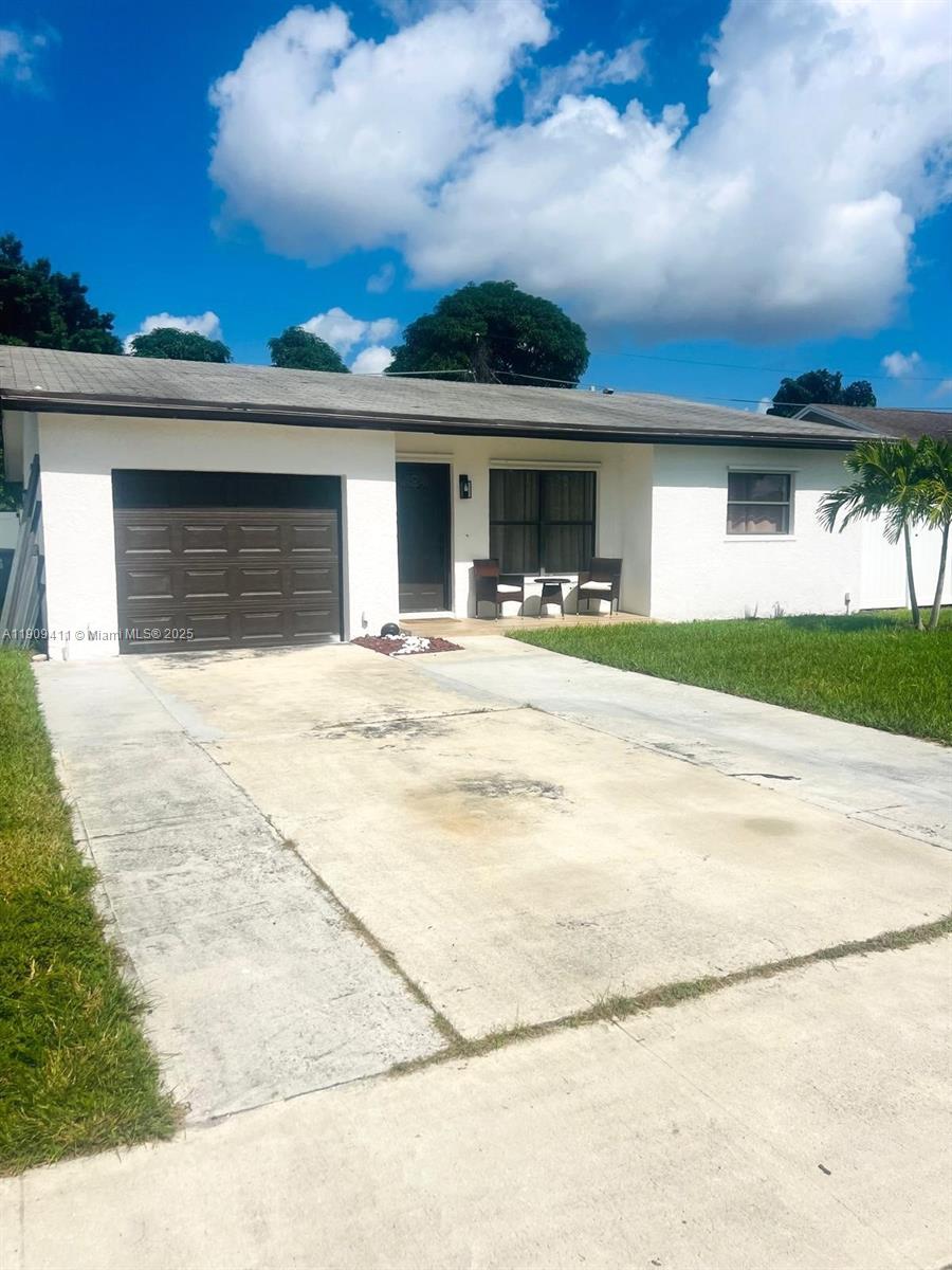 9703 Southwest 2nd Street Boca Raton, FL 33428 - Photo 3 of 17 a front view of a house with a yard and garage
