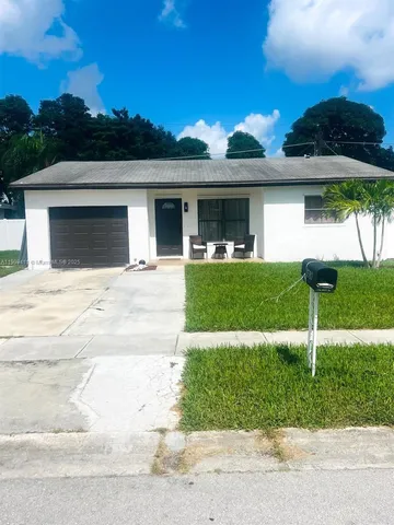 a view of a house with backyard and garden