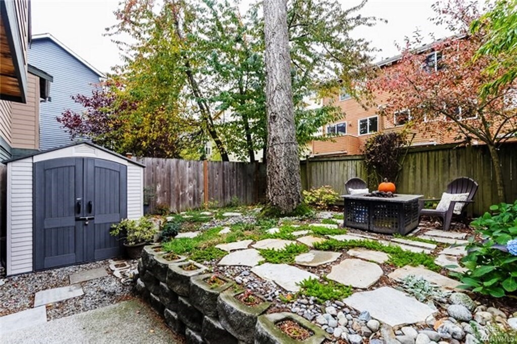 725 North 95th Street, Unit C Seattle, WA 98103 - Photo 17 of 18 a front view of a house with garden and sitting area