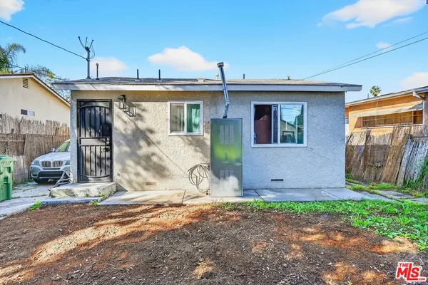 a view of a house with backyard and wooden fence