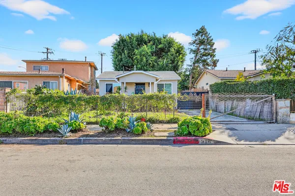 a front view of a house with a yard and potted plants