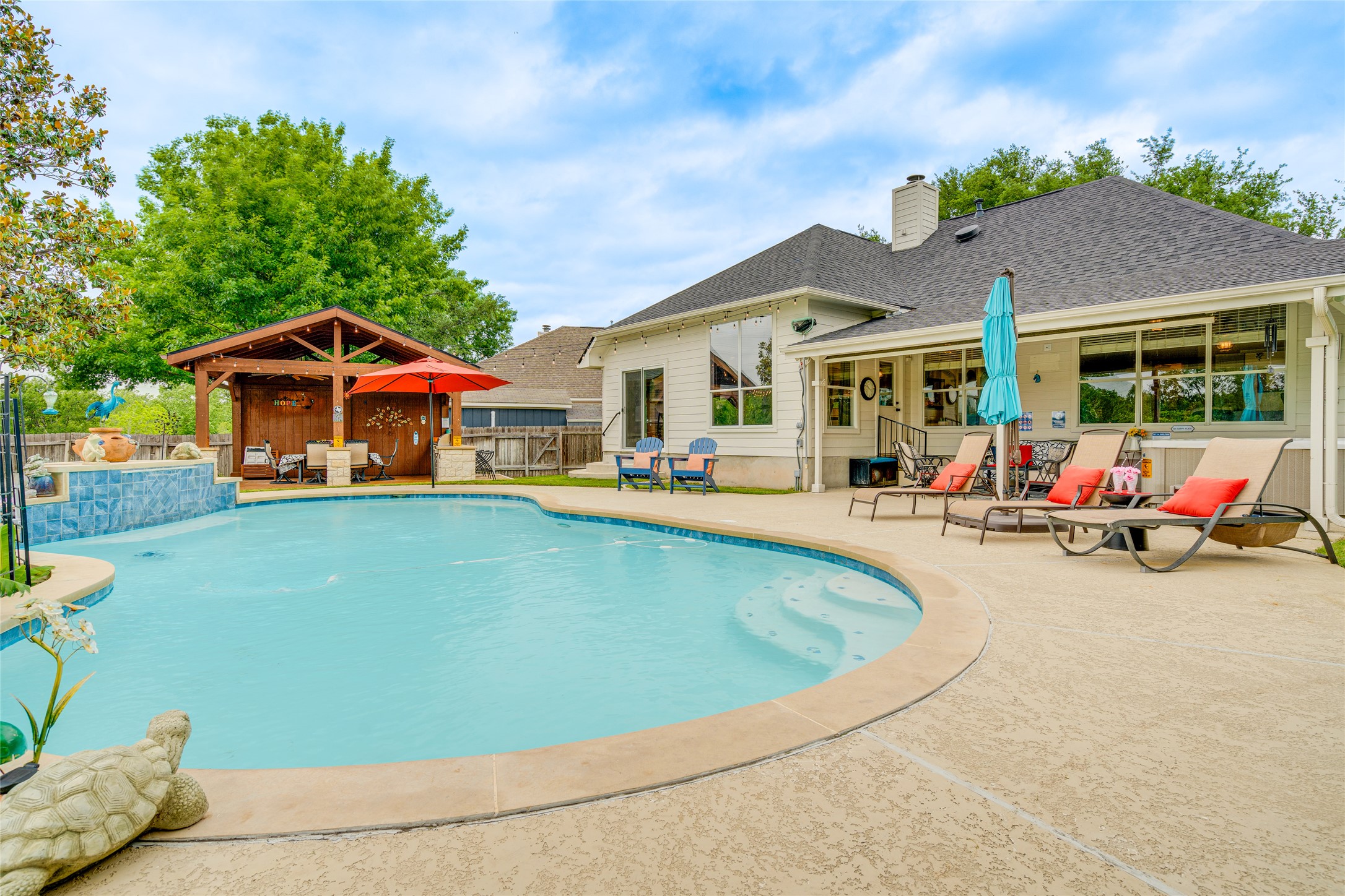 1209 Lacey Oak Loop Round Rock, TX 78681 - Photo 1 of 22 Curved swimming pool with integrated steps, surrounded by a textured concrete patio