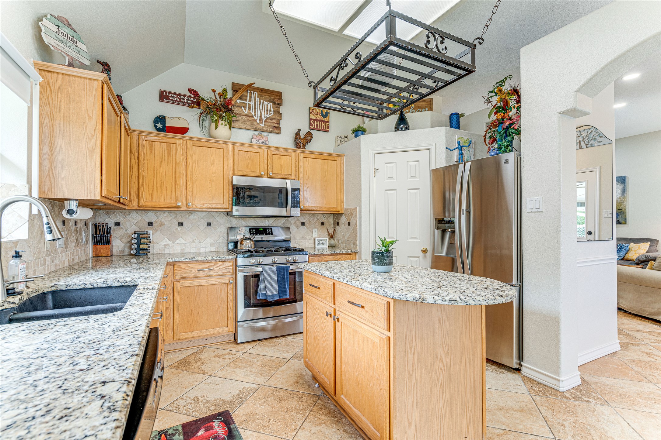1209 Lacey Oak Loop Round Rock, TX 78681 - Photo 15 of 22 Kitchen featuring light wood cabinetry, granite-finish countertops, stainless steel appliances, and a central island
