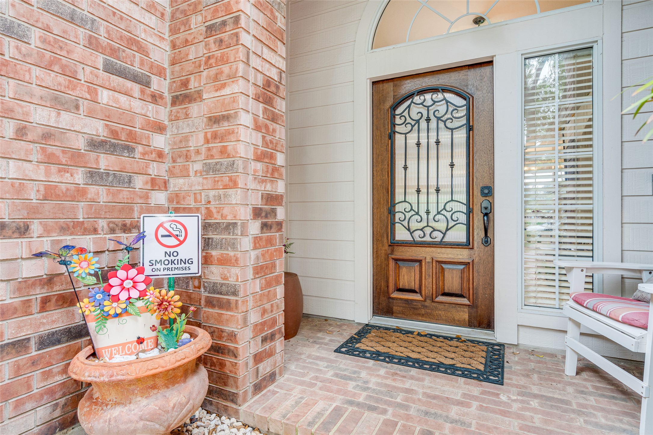 1209 Lacey Oak Loop Round Rock, TX 78681 - Photo 4 of 22 Inviting front entry featuring a wood-panel door with wrought iron and glass inlay, an arched transom window, and a brick facade