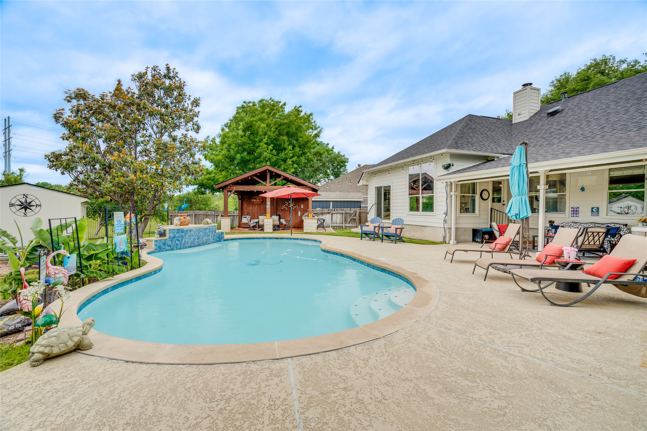 1209 Lacey Oak Loop Round Rock, TX 78681 - Photo 5 of 22 Expansive backyard featuring a custom-shaped swimming pool, a water feature with blue tile, and a wooden gazebo