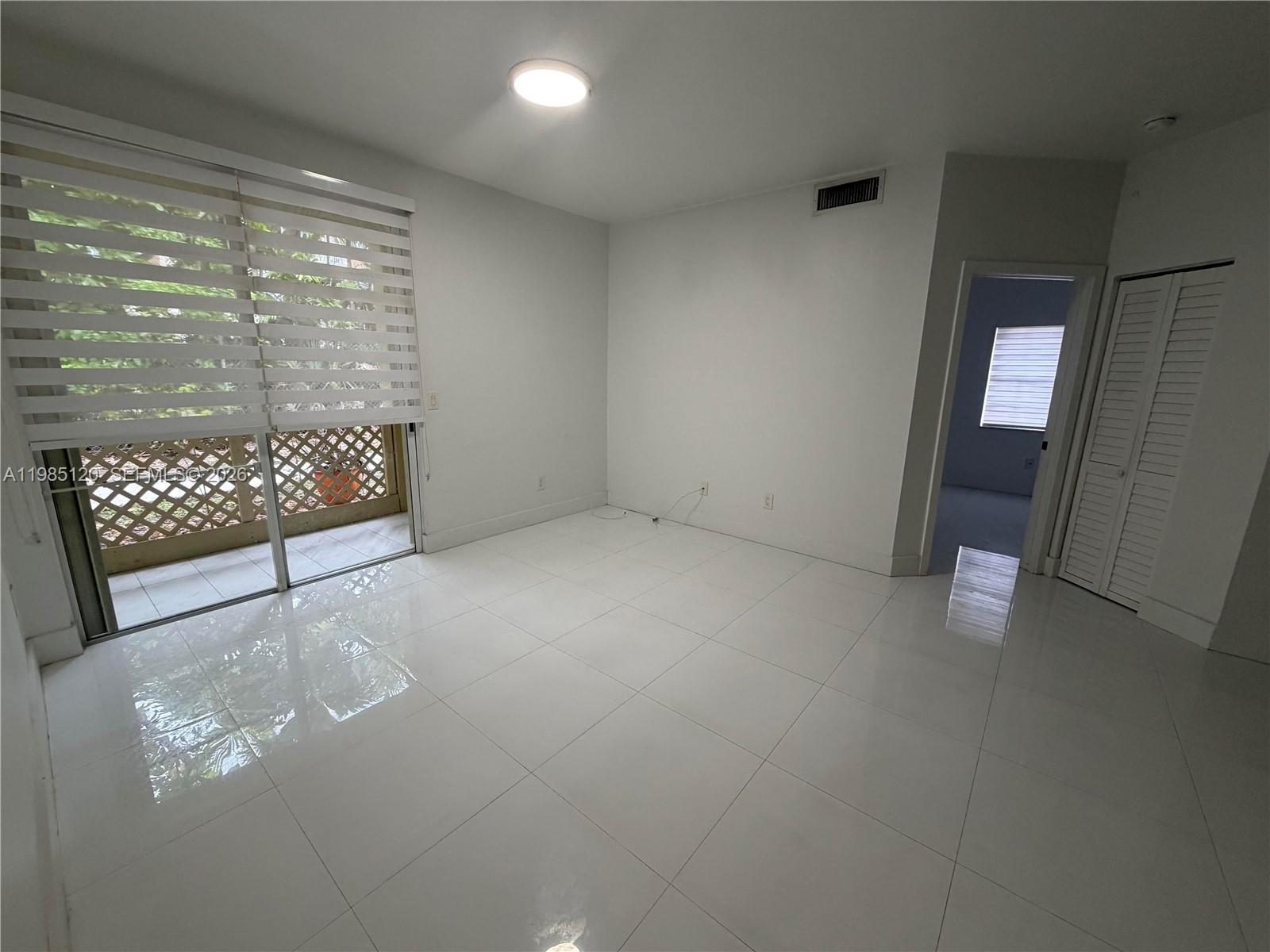 18328 Northwest 68th Avenue, Unit I Hialeah, FL 33015 - Photo 2 of 15 a view of an empty room with a window