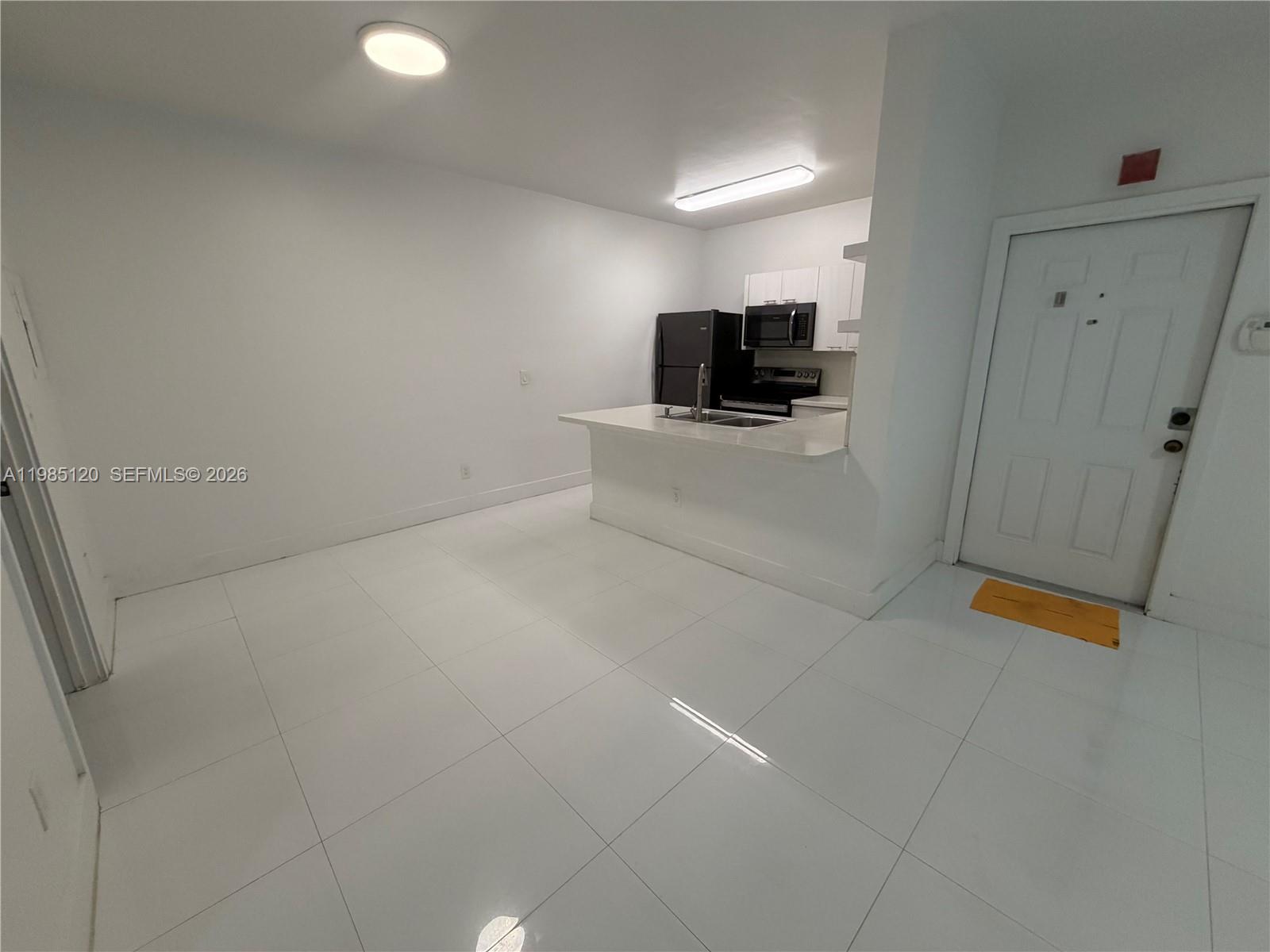 18328 Northwest 68th Avenue, Unit I Hialeah, FL 33015 - Photo 4 of 15 a view of empty room with a flat screen tv