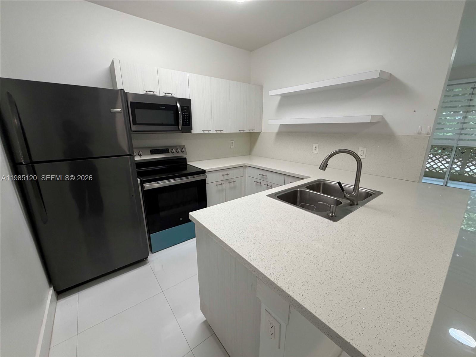 18328 Northwest 68th Avenue, Unit I Hialeah, FL 33015 - Photo 6 of 15 a kitchen with a sink and stainless steel appliances
