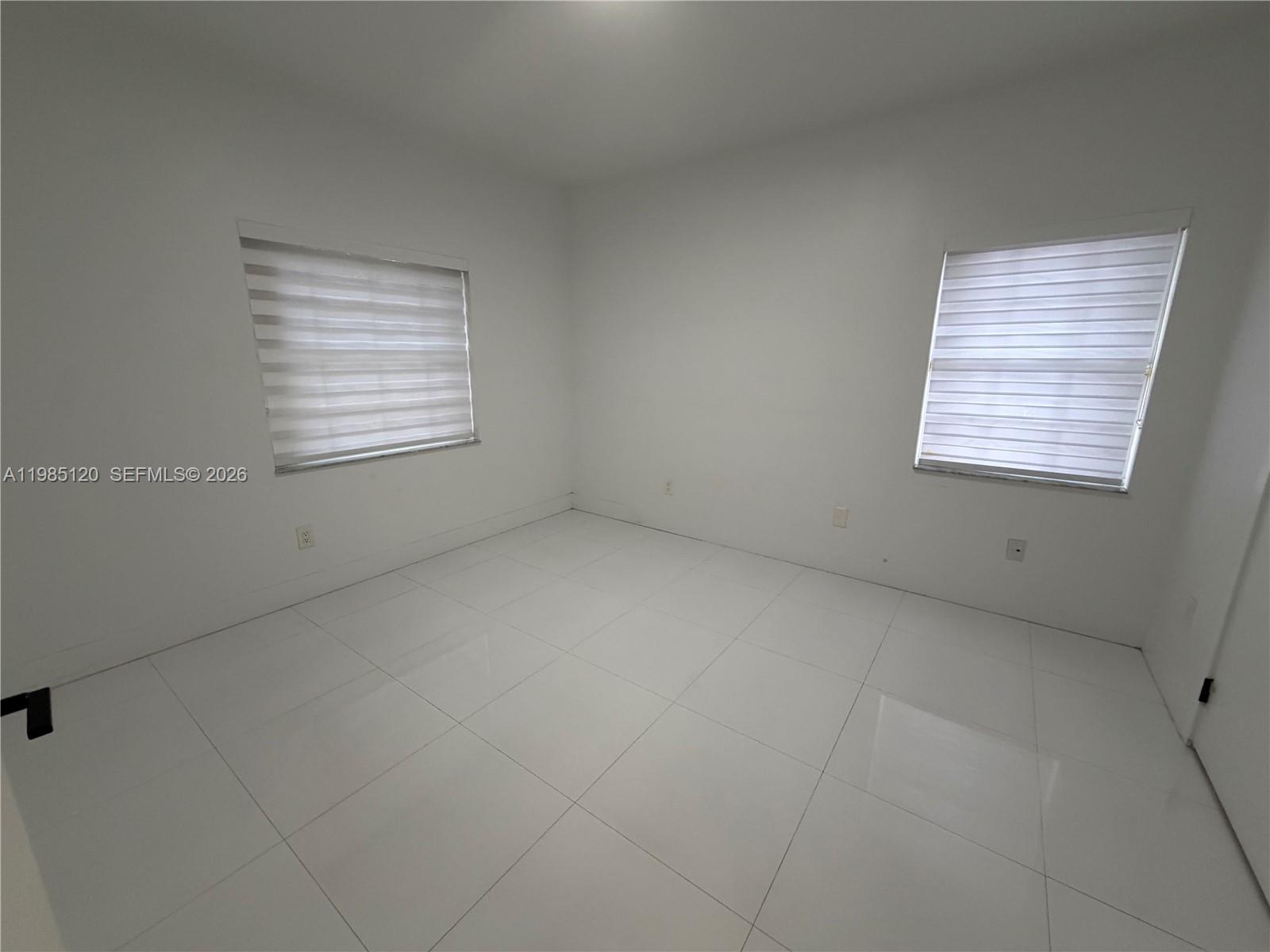 18328 Northwest 68th Avenue, Unit I Hialeah, FL 33015 - Photo 9 of 15 an empty room with a window