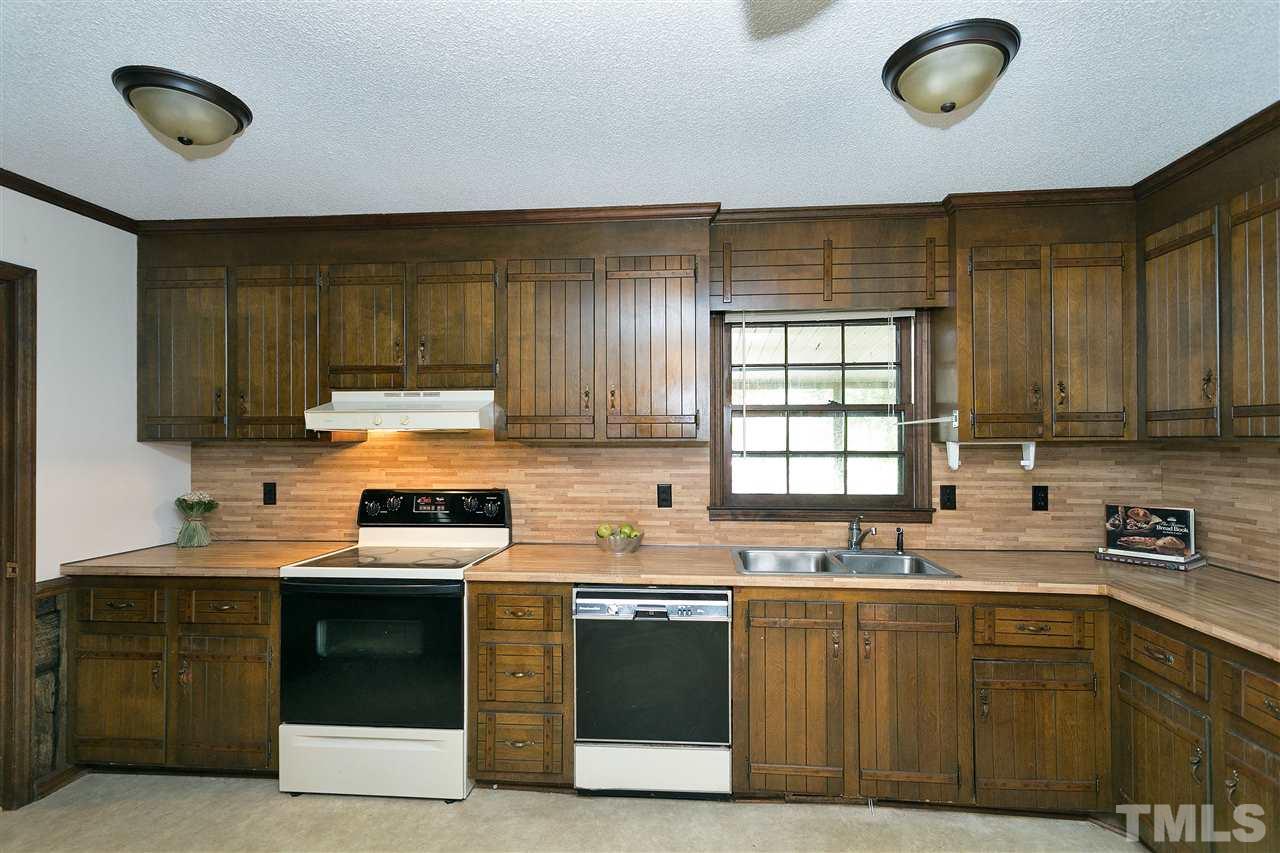 10036 Ten-Ten Road Raleigh, NC 27603 - Photo 11 of 25 a kitchen with stainless steel appliances granite countertop a sink a stove a refrigerator cabinets and a window