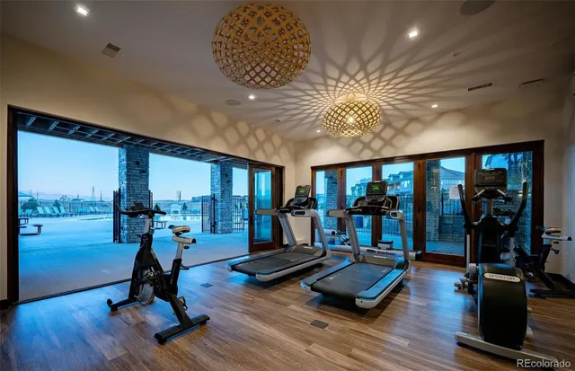 a living room with furniture gym equipment and a large window