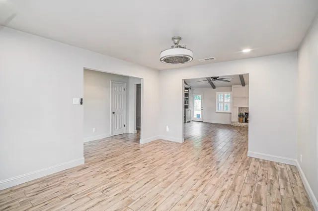 a view of a room with wooden floor and a ceiling fan