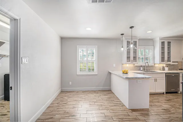 a kitchen with stainless steel appliances granite countertop a sink and a stove with wooden floor