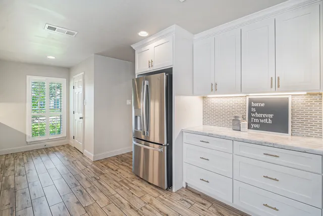 a kitchen with white cabinets and stainless steel appliances