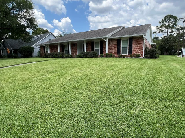 a view of a house with a yard and potted plants