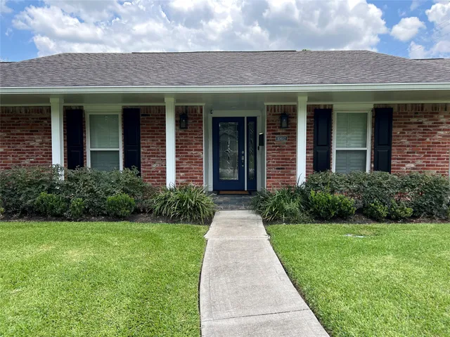 a front view of a brick house with a yard