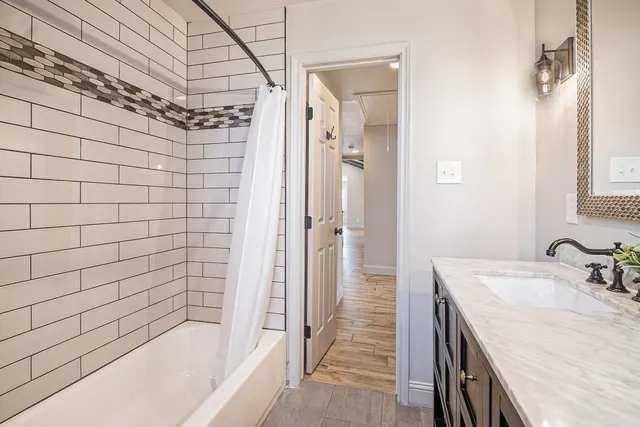 a bathroom with a granite countertop sink a toilet and shower