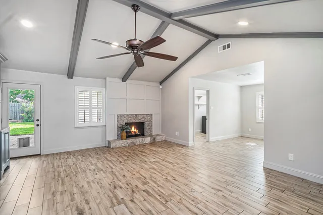 a view of an empty room with a fireplace and a window