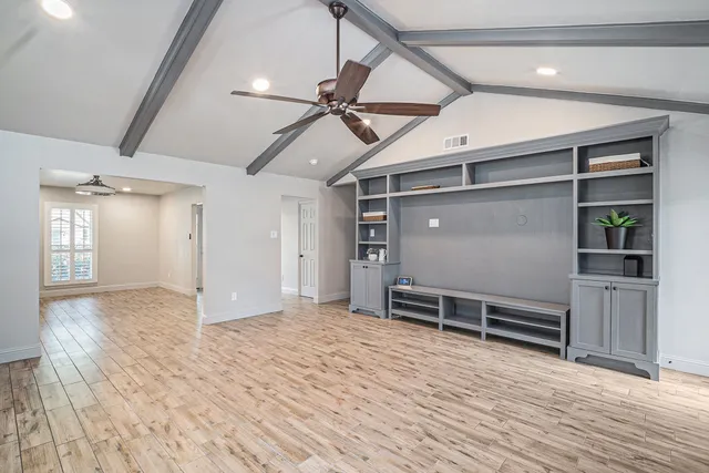 a view of a room with wooden floor and windows