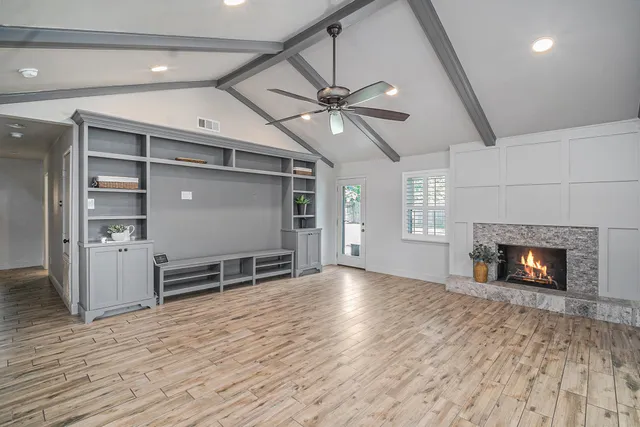 an empty room with windows and fireplace