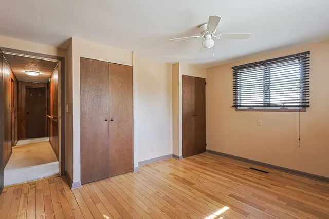 a view of a livingroom with wooden floor and a ceiling fan