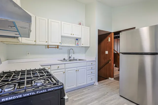 a kitchen with stainless steel appliances granite countertop a refrigerator stove sink and cabinets