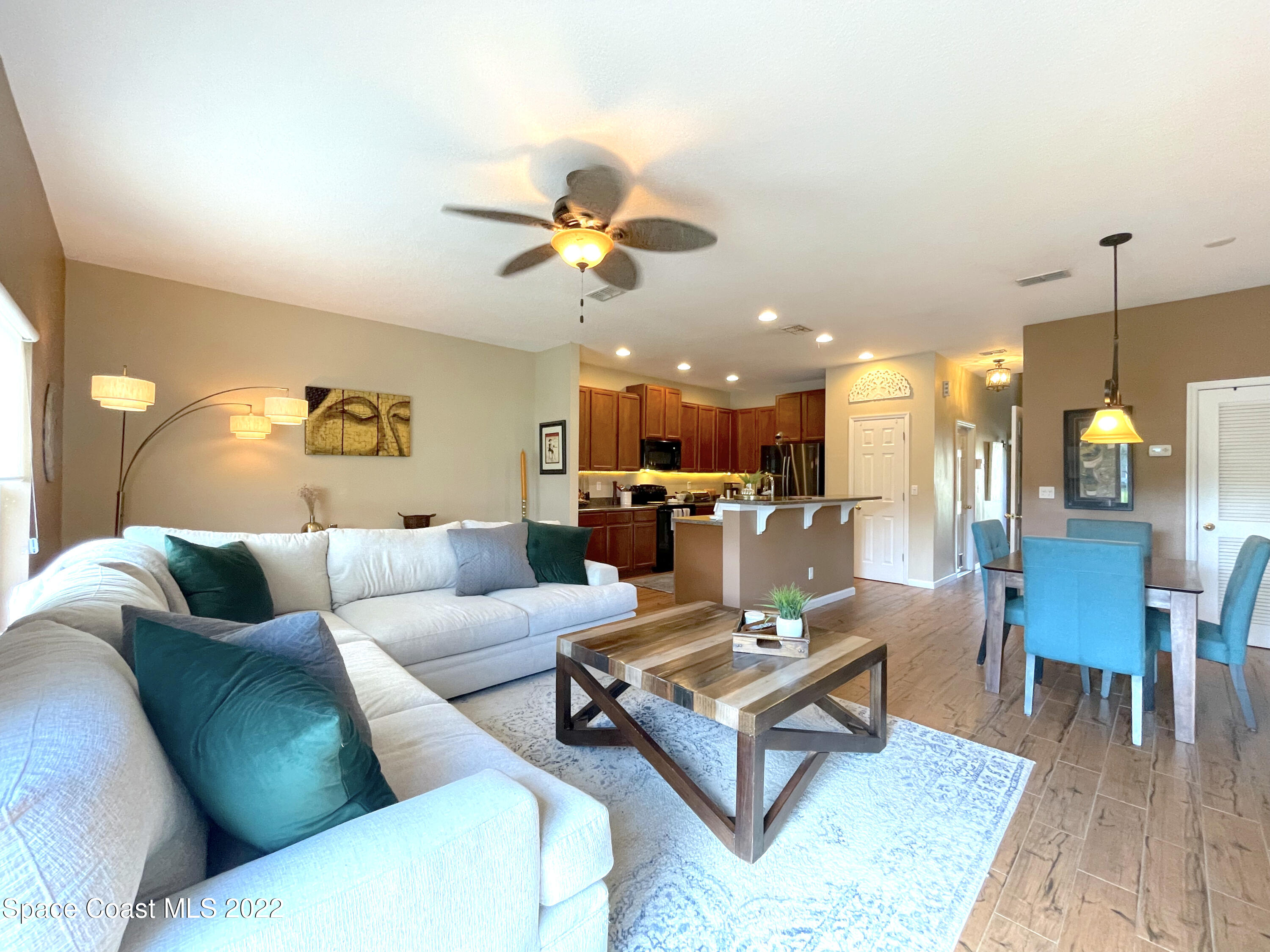 2765 Revolution Street, Unit 101 Melbourne, FL 32935 - Photo 12 of 48 a living room with furniture kitchen view and a chandelier