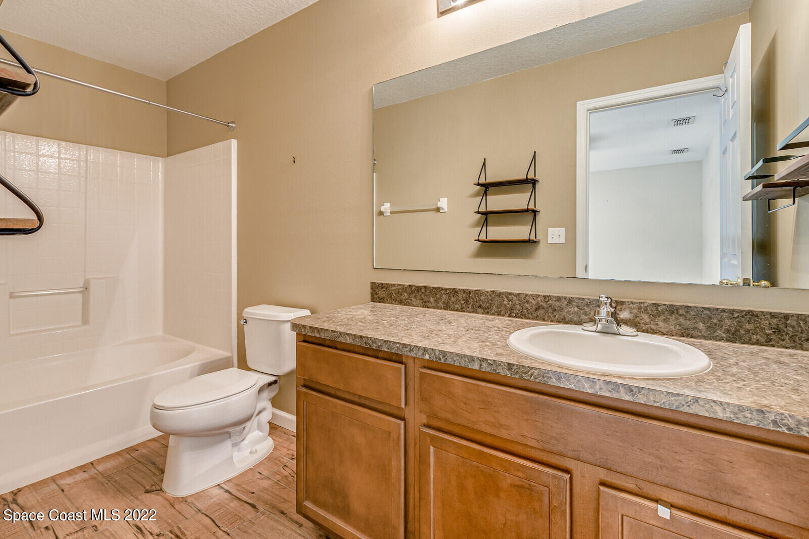 2765 Revolution Street, Unit 101 Melbourne, FL 32935 - Photo 16 of 48 a bathroom with a granite countertop sink toilet and shower