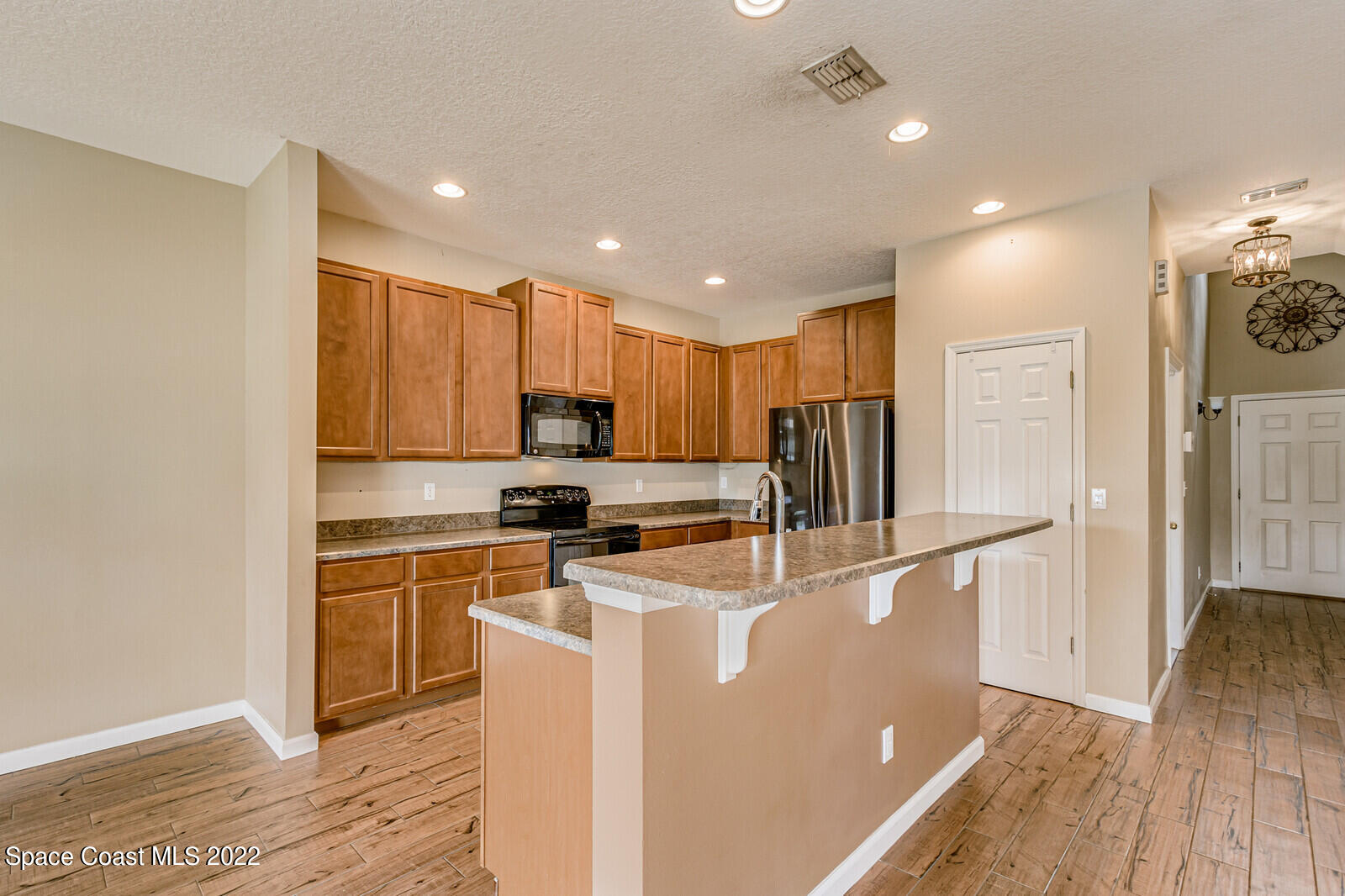 2765 Revolution Street, Unit 101 Melbourne, FL 32935 - Photo 4 of 48 a kitchen with stainless steel appliances granite countertop a refrigerator a stove top oven a sink and dishwasher