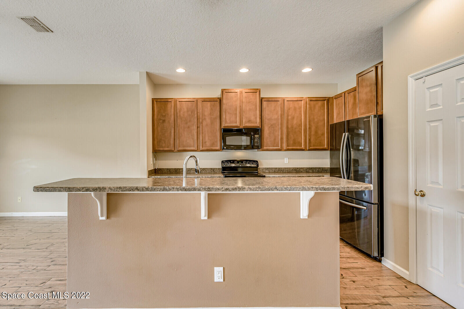 2765 Revolution Street, Unit 101 Melbourne, FL 32935 - Photo 6 of 48 a kitchen with stainless steel appliances granite countertop a refrigerator a sink a stove and oven