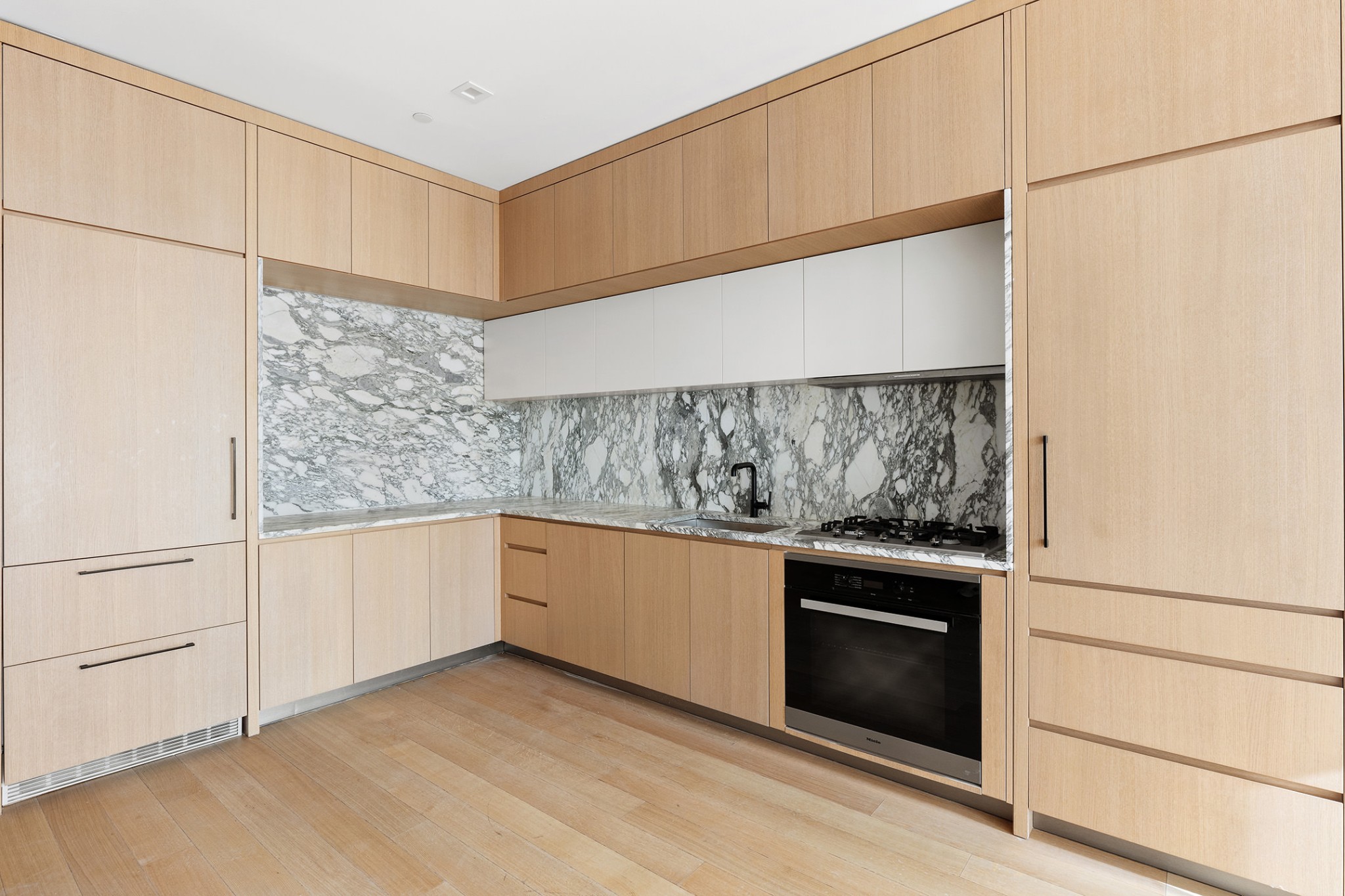 517 West 29th Street, Unit 3D Manhattan, NY 10001 - Photo 3 of 16 a kitchen with white cabinets and white appliances