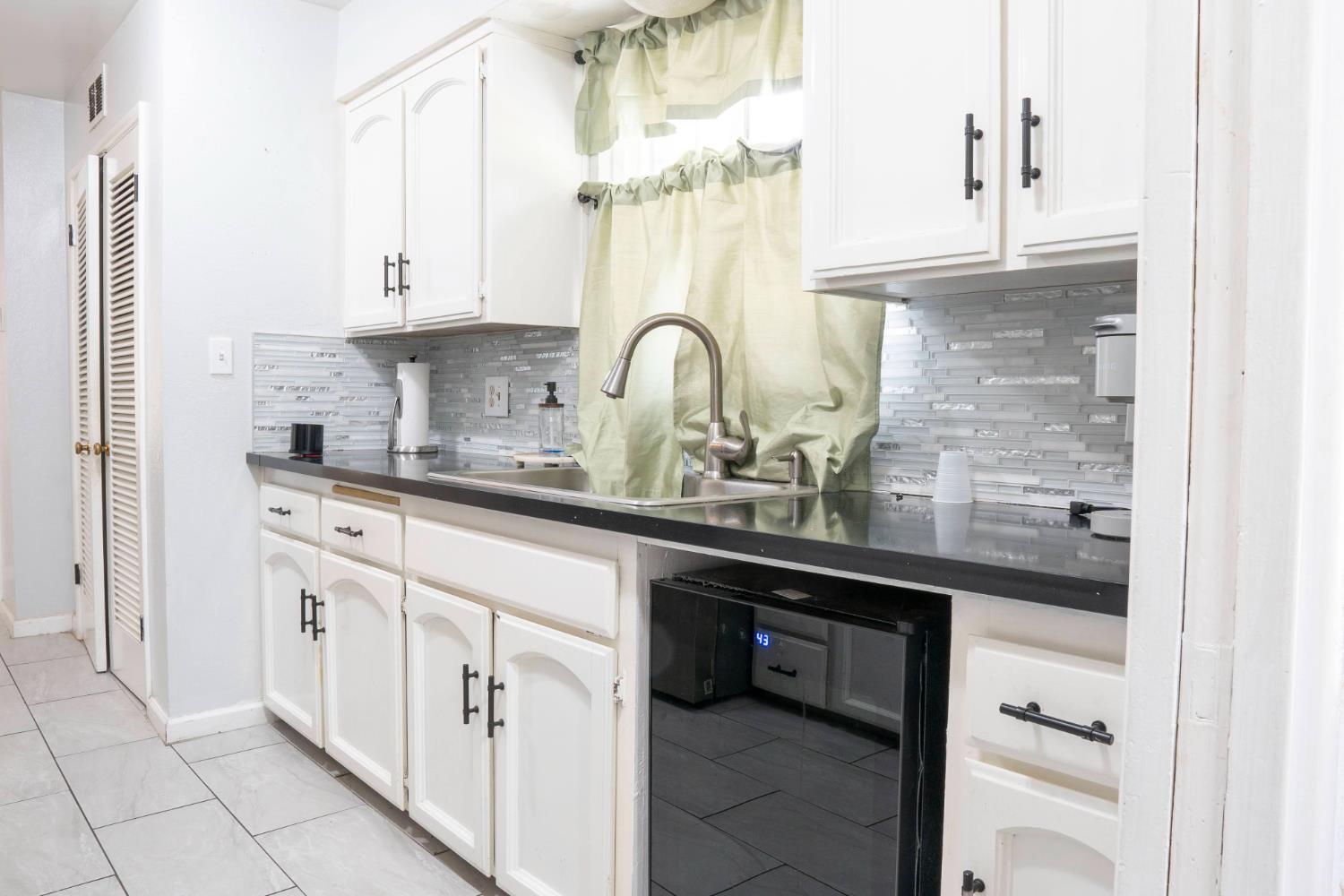 3662 North Angus Street Fresno, CA 93726 - Photo 15 of 67 a kitchen with white cabinets and a sink