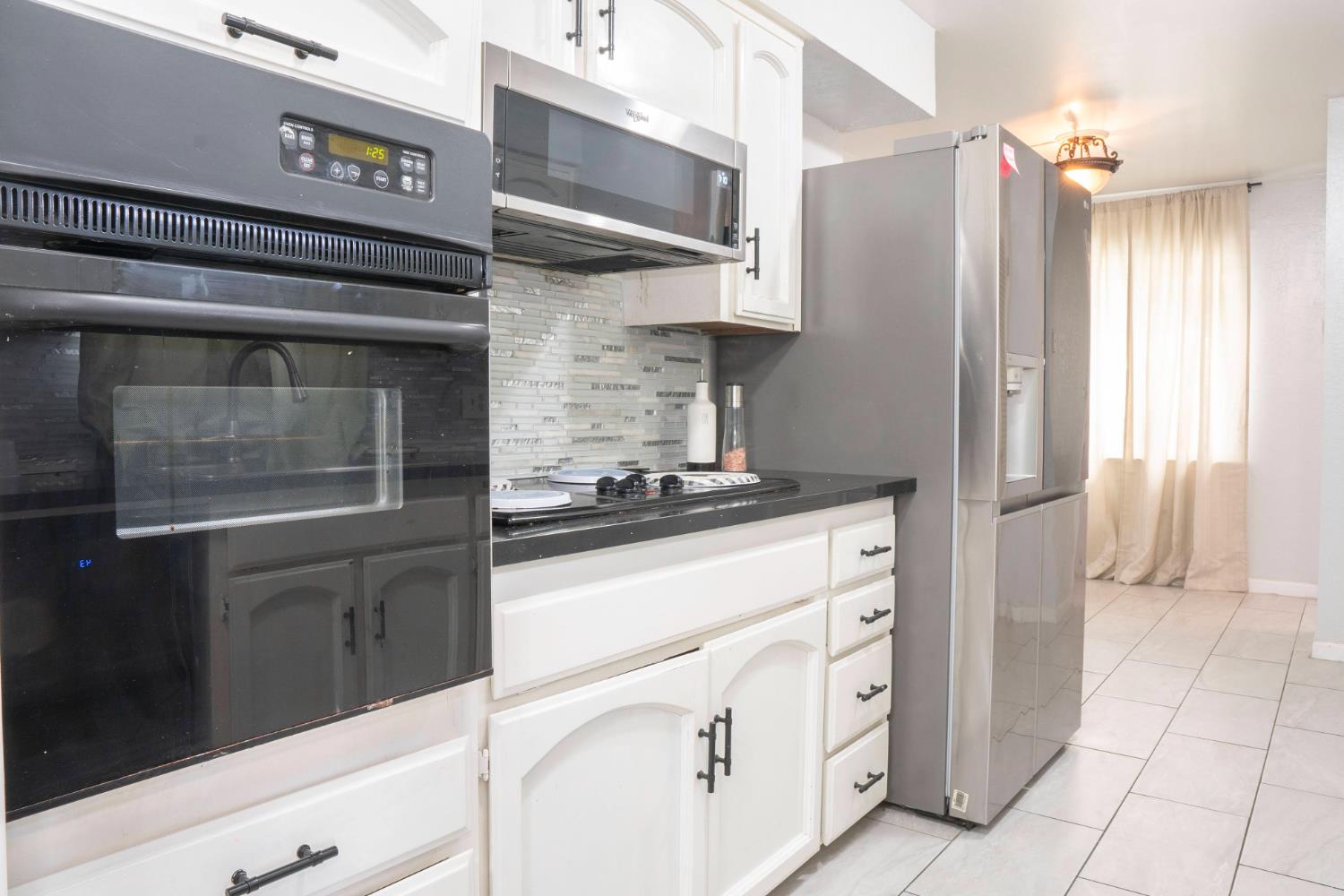 3662 North Angus Street Fresno, CA 93726 - Photo 16 of 67 a kitchen with stainless steel appliances granite countertop a stove and a refrigerator