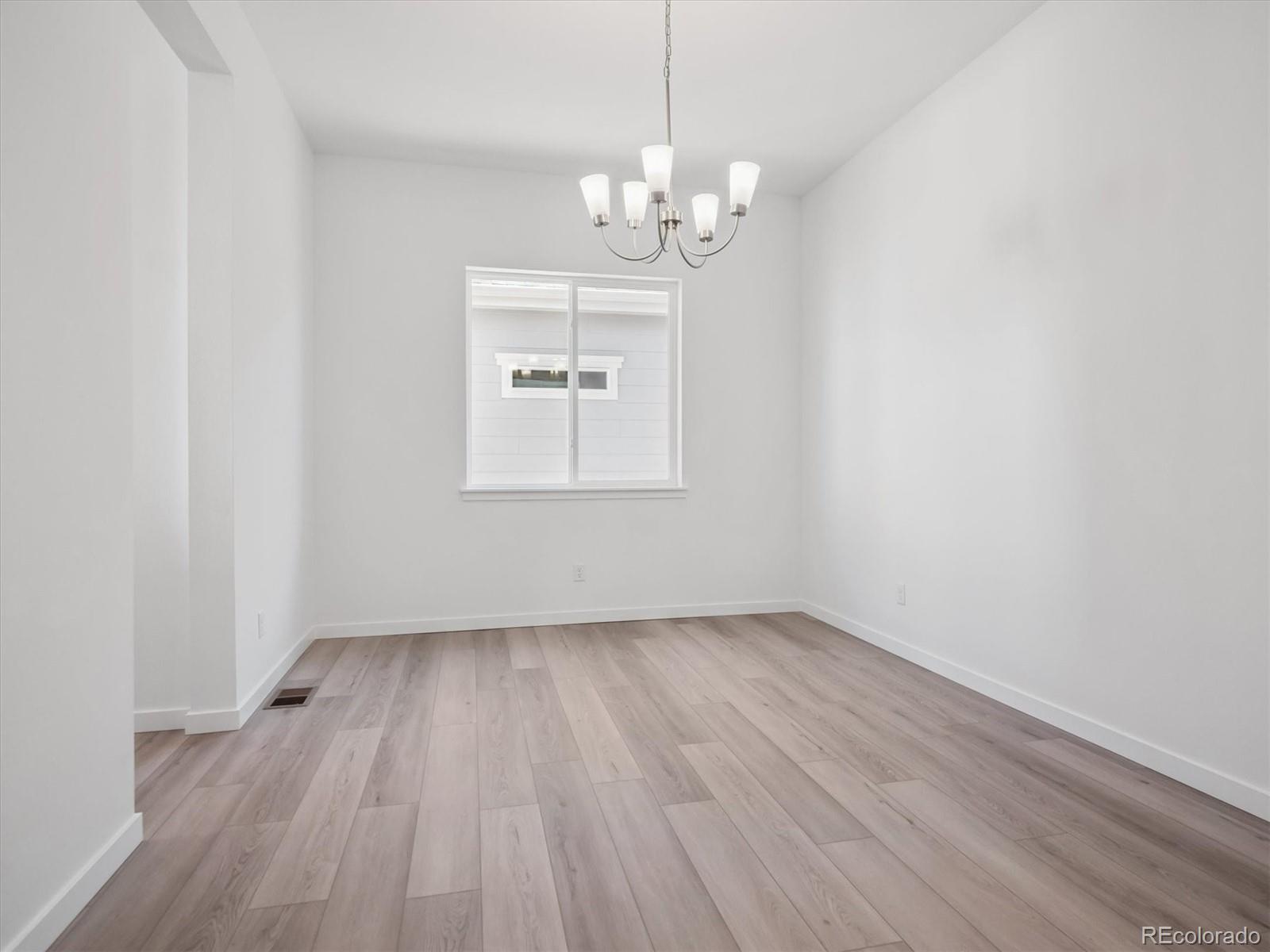 9178 Gold Lace Place Littleton, CO 80129 - Photo 13 of 26 a view of an empty room with wooden floor and a window