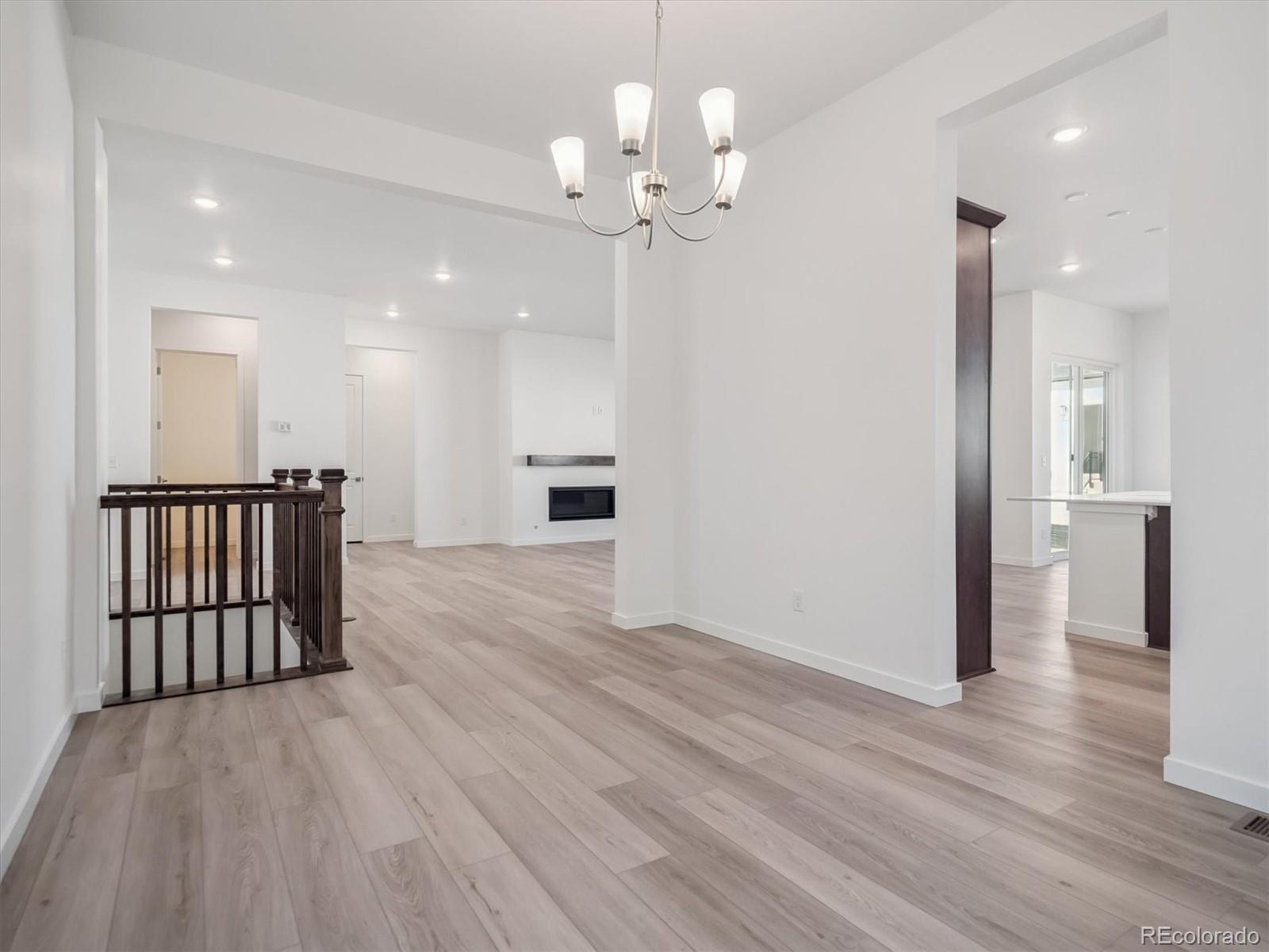9178 Gold Lace Place Littleton, CO 80129 - Photo 14 of 26 a view of a hallway with wooden floor and a large mirror