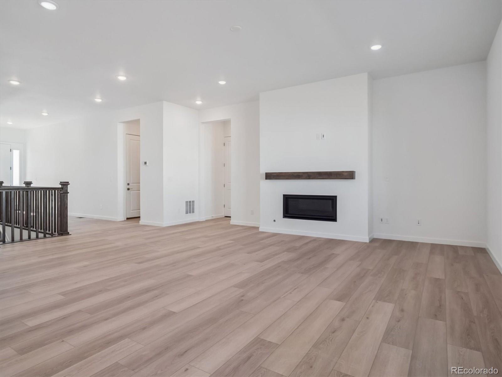 9178 Gold Lace Place Littleton, CO 80129 - Photo 9 of 26 a view of empty room with wooden floor and fireplace