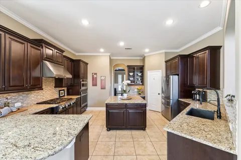 a kitchen with stainless steel appliances granite countertop a sink stove and refrigerator