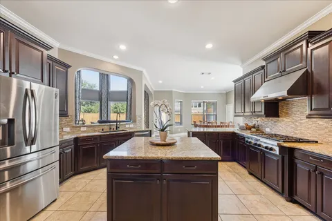 a kitchen with stainless steel appliances granite countertop a sink stove and refrigerator