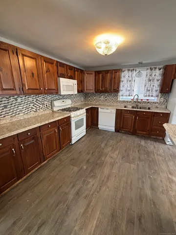 a large kitchen with lots of counter space and wooden floor