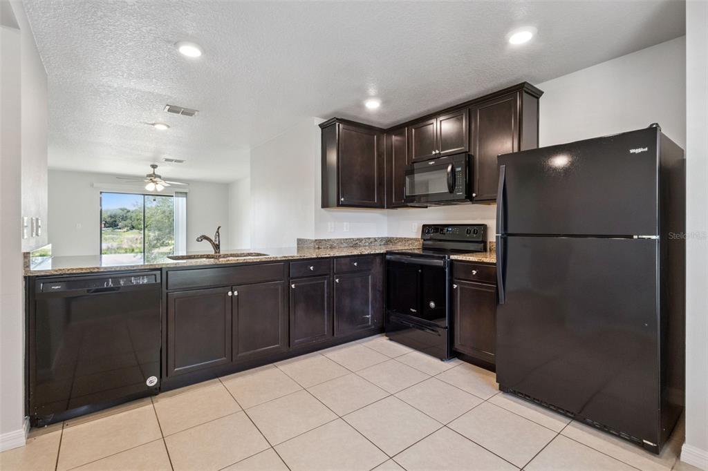 1613 Orne Street Mascotte, FL 34753 - Photo 7 of 31 a kitchen with a refrigerator and a sink