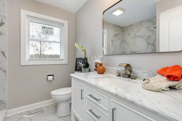 a bathroom with a sink a toilet and mirror