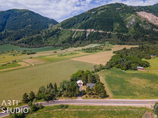 2807 North Ogden Canyon Road Eden, UT 84310 - Photo 65 of 72 Expansive rural setting featuring a main residence, a barn, and a secondary structure amidst cultivated fields and dense woodland