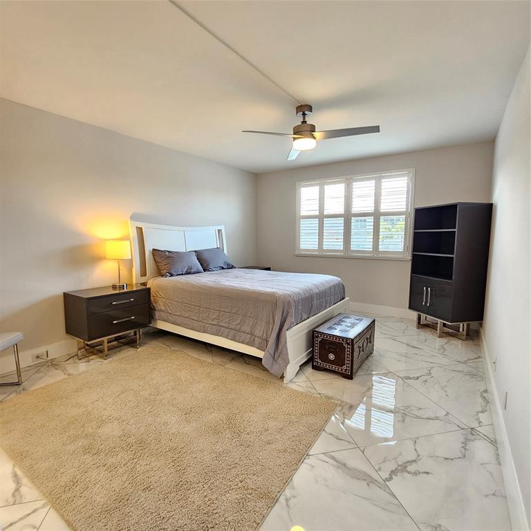 1705 Andros Isle, Unit C3 Coconut Creek, FL 33066 - Photo 13 of 36 a bedroom with a bed and a flat screen tv